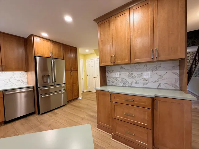 A spacious kitchen emerged after we removed walls, installed new cabinets, and added stylish lighting.