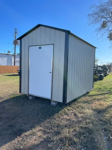 photo at Kilgore, TX on Jan 15, 2026: 8x12 gable storage building in Lightstone with black trim4' wide man door, solid flooring, welded 
