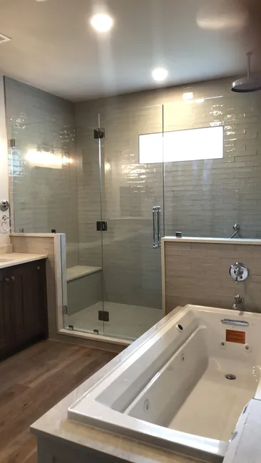 A sleek swinging door glass enclosure was installed in this master bathroom, elevating both style and function.