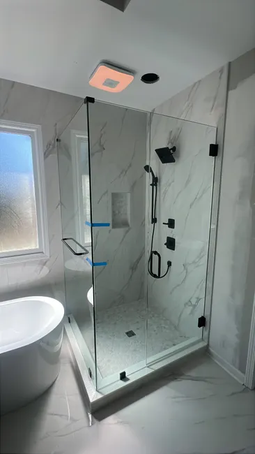 We installed a sleek 3-panel swing door in clear tempered glass, enhancing the master shower with style and function.