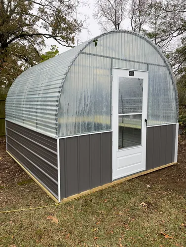 photo at White Oak, TX on Dec 11, 2025: 10X12 Greenhouse with fiberglass roof and metal sidesCharcoal Gray with white trimtreated shelvin
