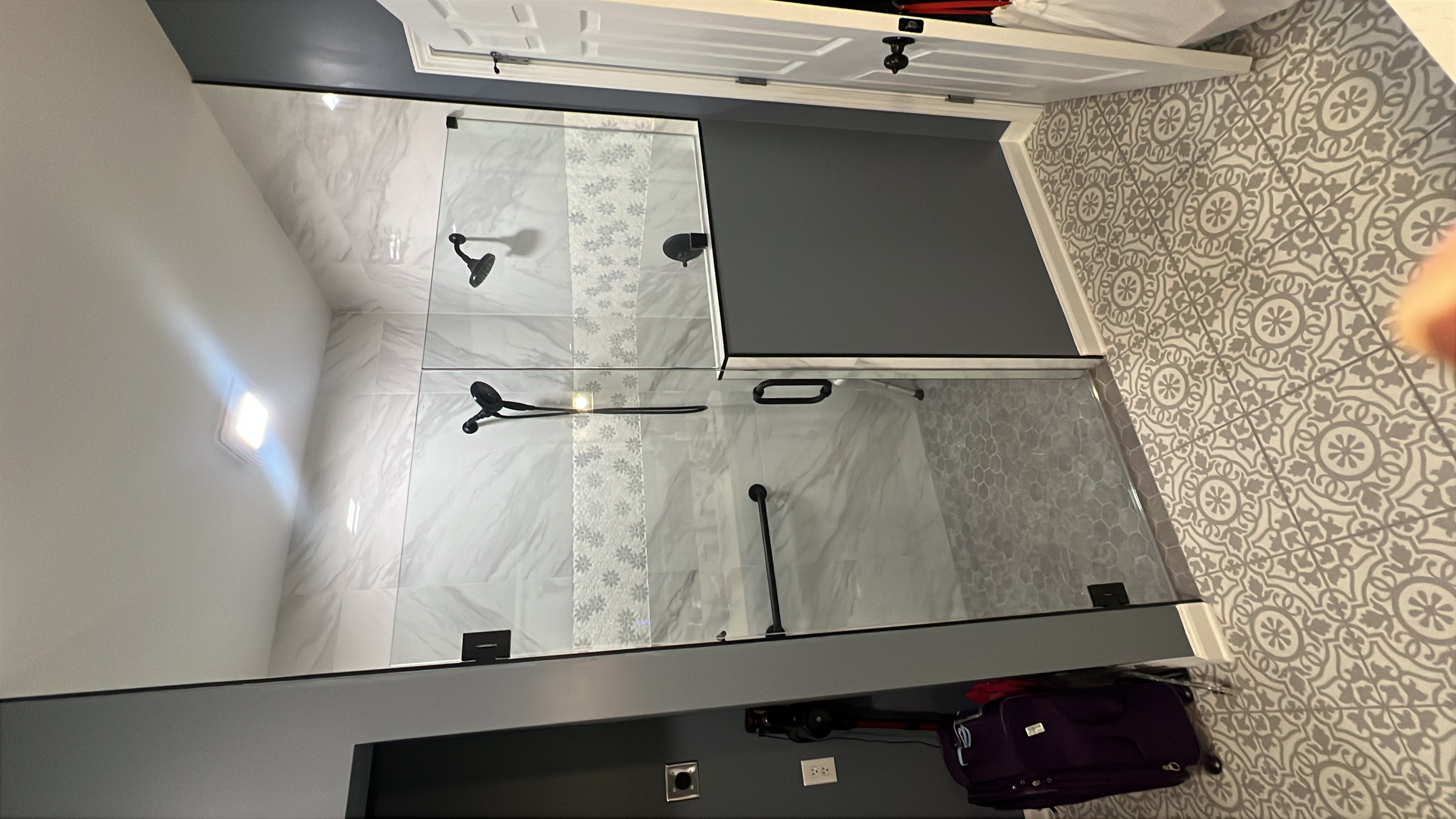 Three-panel glass shower enclosure with matte black hardware in a Sharpsburg, GA home