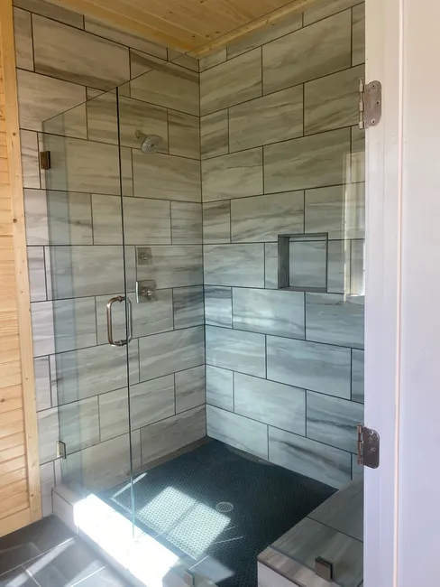 A two panel frameless glass enclosure, 1/2 fixed panel with a 3/8 swing door.