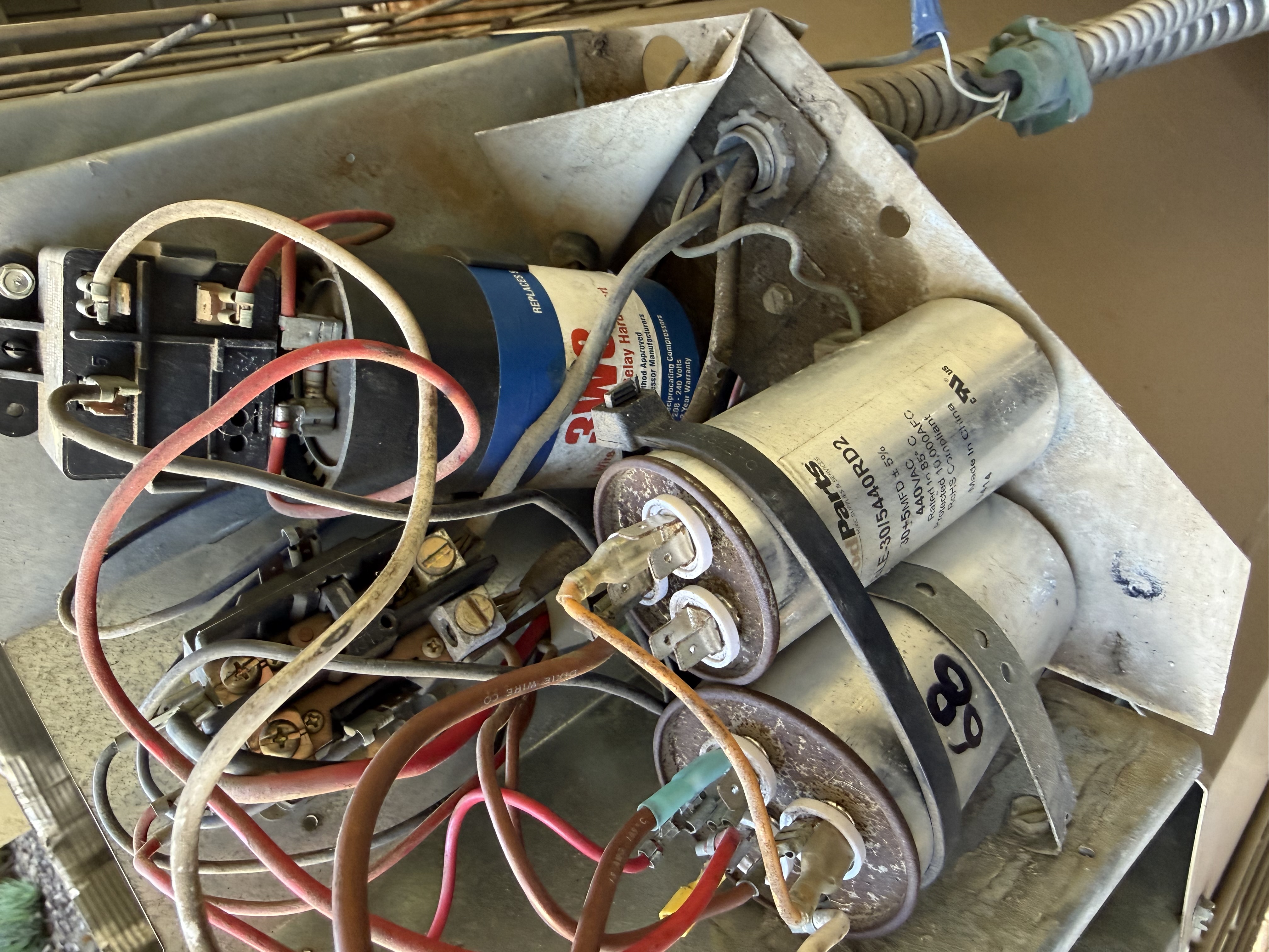 Capacitors and wiring inside an air conditioning unit checked during a tune-up in Roseville, CA