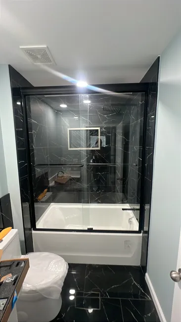 A stylish dual-panel shower enclosure was installed in the Master bathroom, featuring sleek 3/8