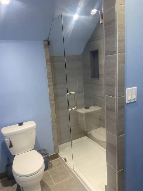 2 Panel Frameless Glass Shower Enclosure with Brushed Nickel Hinges, Clips, and Handle - Swing door is on the right with the fixed panel on the left - glass cut an an angle to fit perfectly to the ceiling