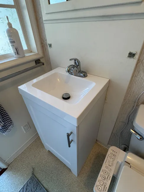 A dated pedestal sink was replaced with a stylish vanity, enhancing both functionality and storage in the bathroom.