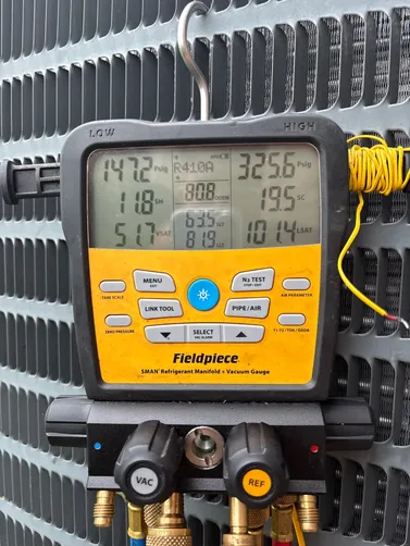 Diagnostic gauges on an outdoor air conditioner at a Chelsea service visit