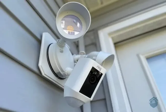 To enhance home security, we installed power above the garage and wired a floodlight for automatic illumination.