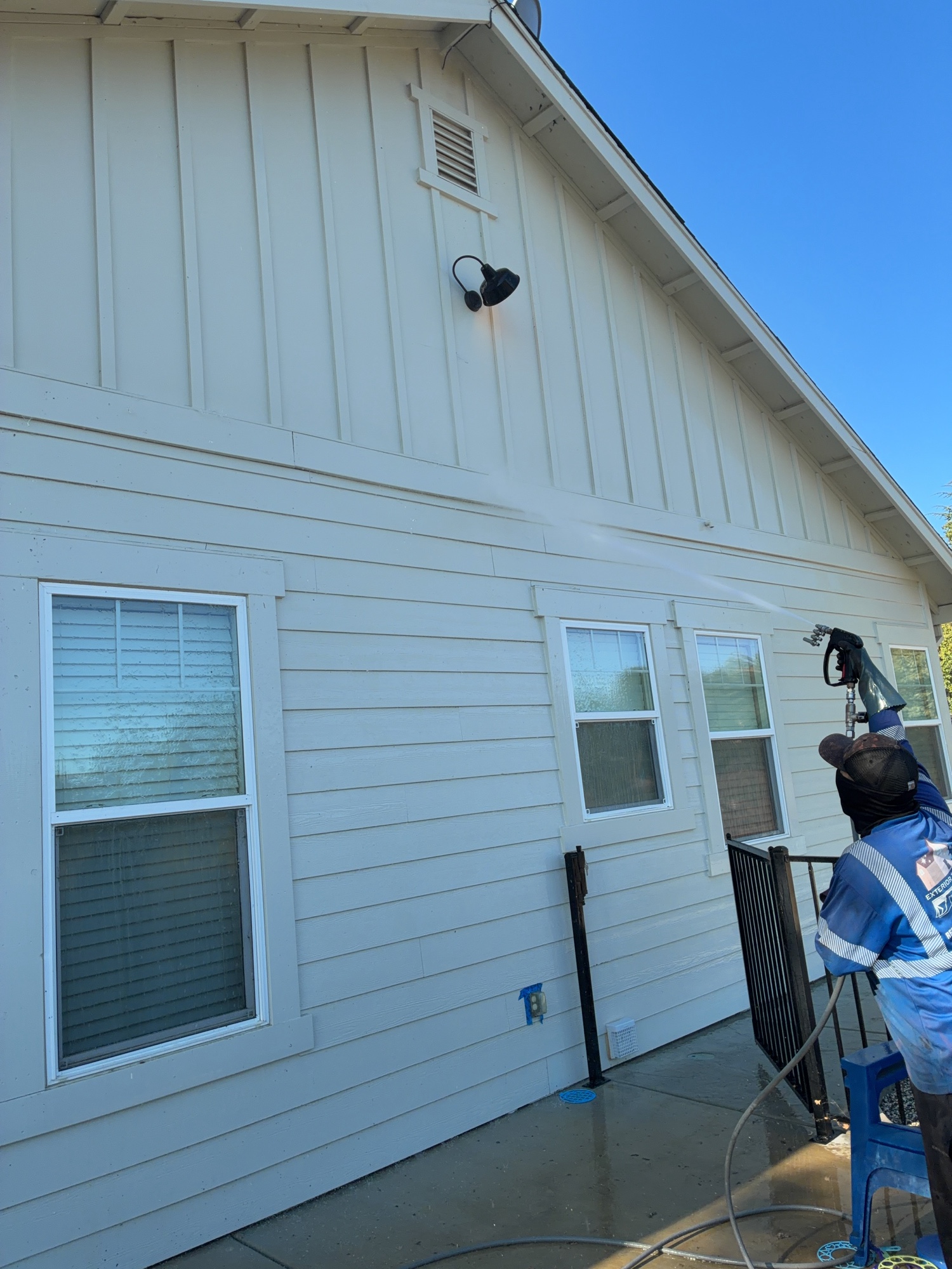 Technician soft washing the siding of a Fairfield, CA home