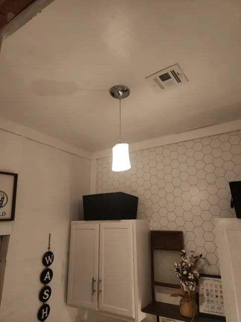 The laundry room's lighting was upgraded with new wiring and a central fixture for enhanced illumination.