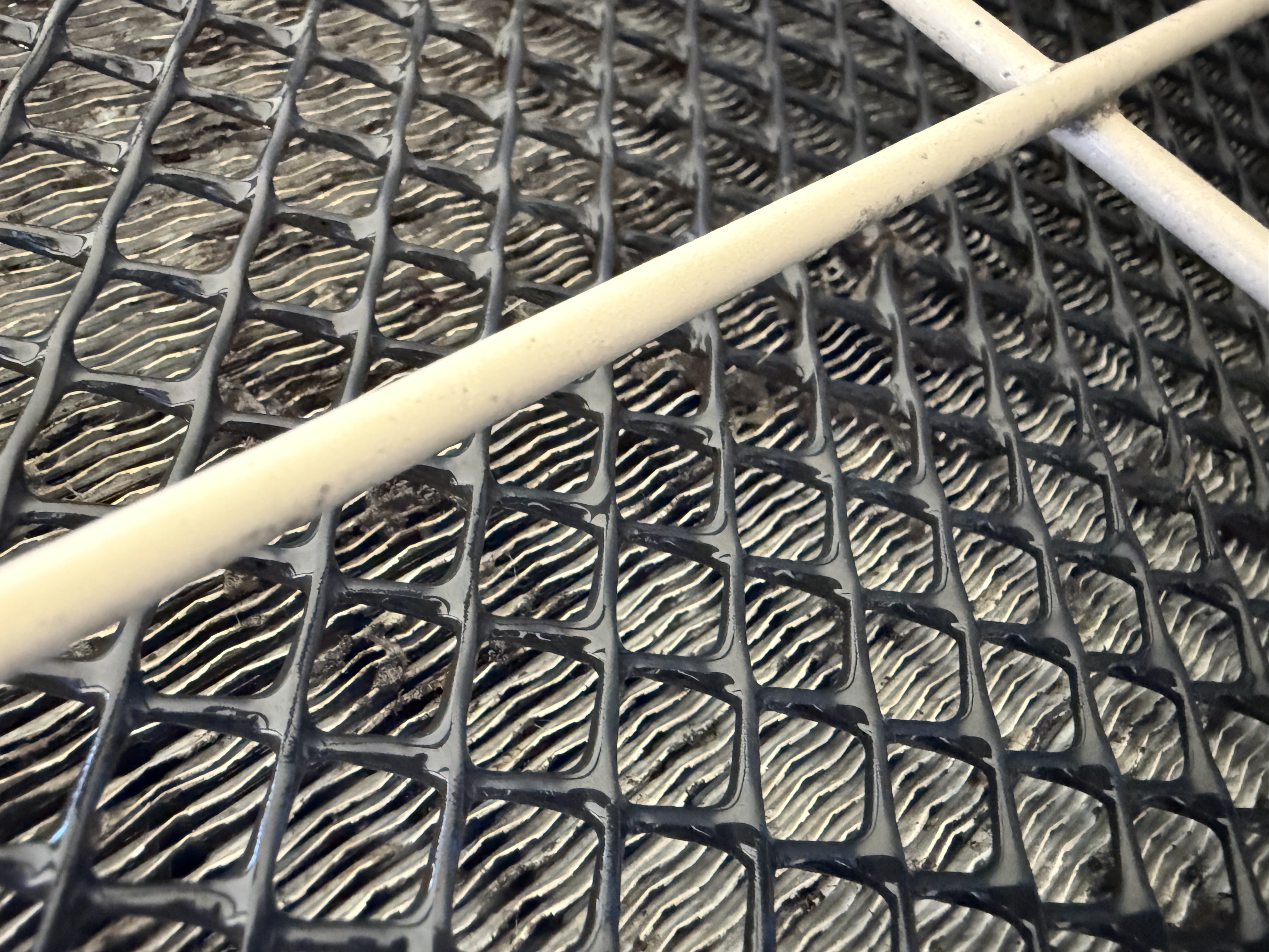 Condenser coil of an air conditioning unit during a tune-up in Roseville, CA