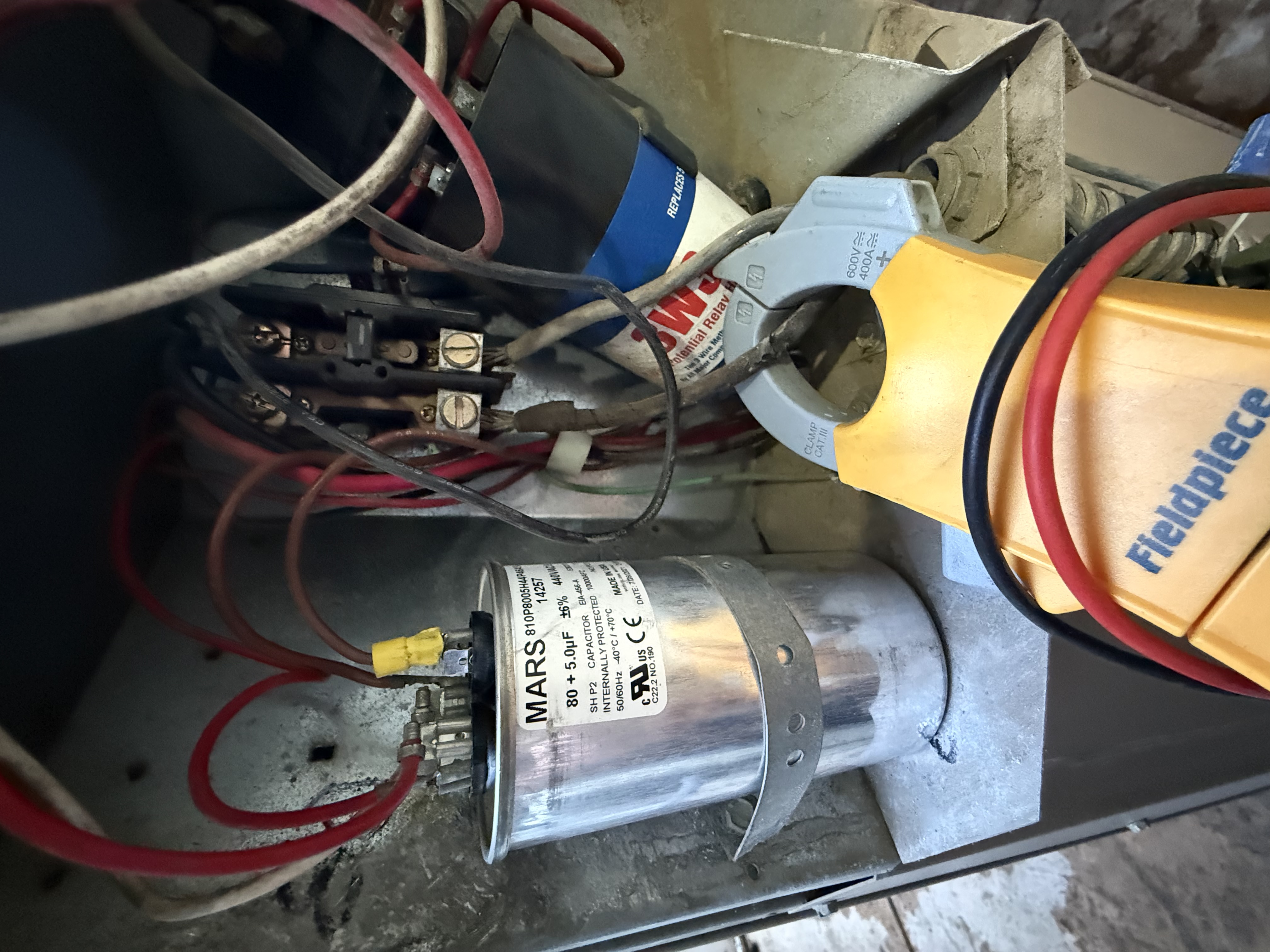Close-up of the electrical components inside a central air conditioner during a tune-up in Roseville, CA