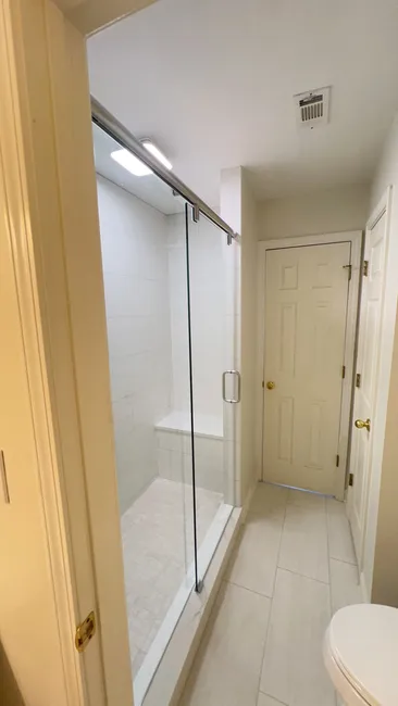 At a residential property, we installed a stylish hydro slide system featuring clear tempered glass, chrome hardware, and a sleek design—perfect for enhancing the master suite.