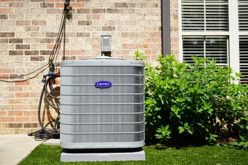 Carrier outdoor air conditioner installed beside an Irondale home