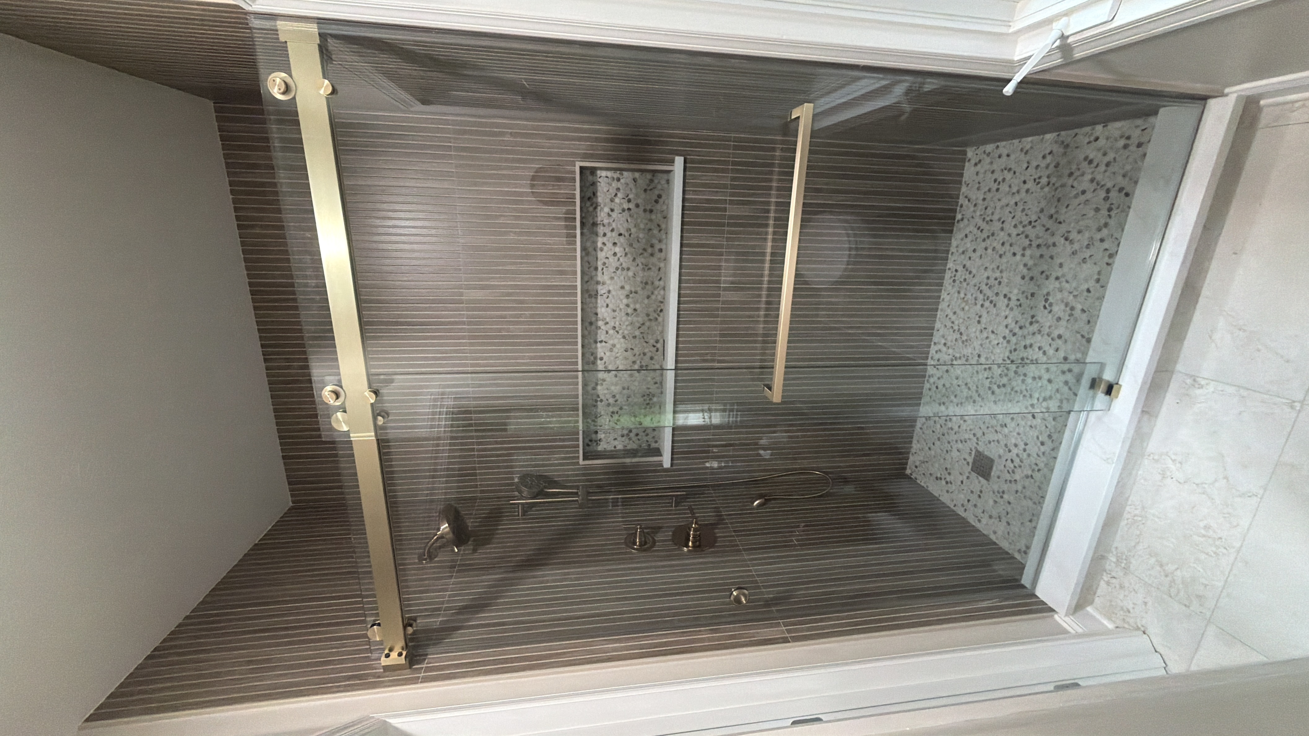 Bypass sliding shower door with brushed bronze hardware in a Senoia, GA bathroom