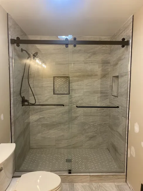2 Panel Frameless Glass Sliding Bypass Shower Enclosure with Matte Black Slider and Hardware - Both doors are sliding so the shower can be opened form either side and also has a towel bar on each door - one inside and one outside.