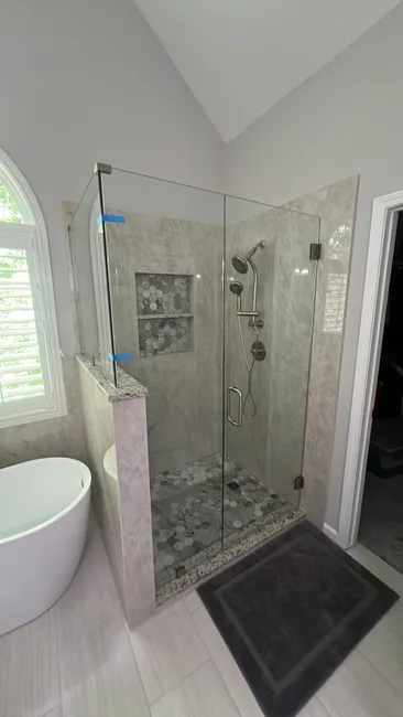To enhance the shower space, we installed a sleek 3-panel glass enclosure with a stylish swinging door.