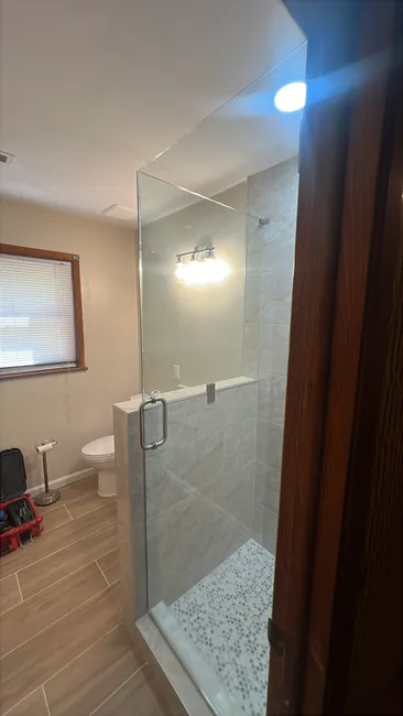 We installed a stylish glass shower enclosure in the basement, enhancing the space with modern brushed nickel hardware.